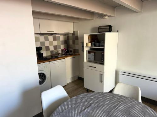 une cuisine avec des armoires blanches et une laveuse et une sécheuse dans l'établissement ღ Le Petit Buffet Hyper Centre, à La Rochelle