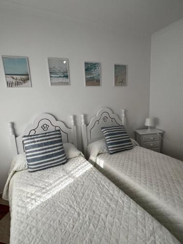 a bedroom with two beds and two pictures on the wall at Casas PARAJE NATURAL in Zahara de la Sierra