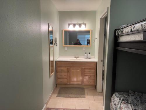 a bathroom with a sink and a mirror and a bed at RR-Birch_Creek 2 in June Lake