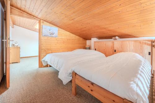 une chambre avec un lit dans une pièce en bois dans l'établissement Alpenlake AP117 LAKE & VIEW 6 Pers, à Châtel