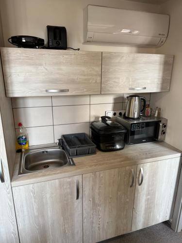 a small kitchen with a sink and a microwave at Resort Mezná in Hřensko