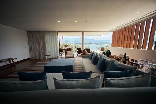 a room with couches and chairs and a large window at Hotel Fasano Angra dos Reis in Angra dos Reis