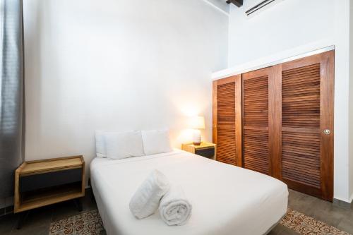 a bedroom with a white bed and a wooden closet at Casa Las Ruinas by Stay with Bear in San Juan