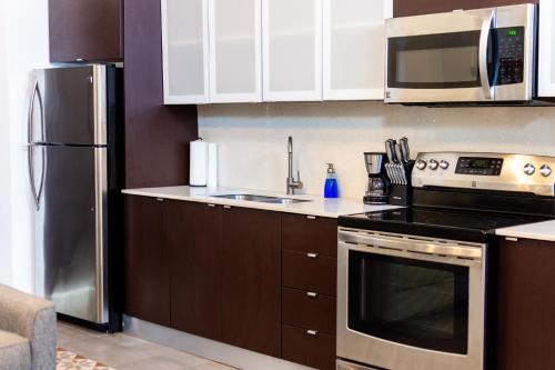 a kitchen with white cabinets and a stove top oven at Casa Las Ruinas by Stay with Bear in San Juan