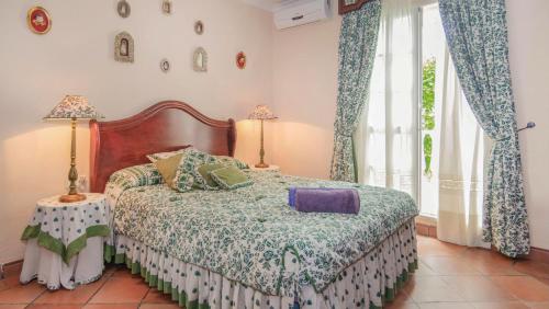 a bedroom with a bed and two lamps and a window at Villa Delta by Casitas Select in Córdoba