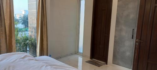 a bedroom with a bed and a large window at Oasis Suits DHA in Lahore