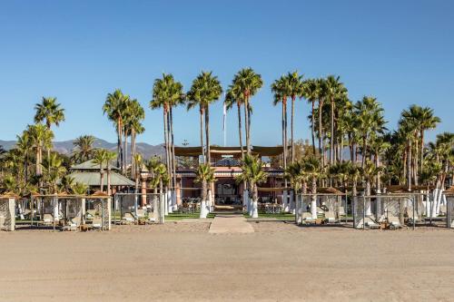 a resort with palm trees in front of a building at Anantara Villa Padierna Palace Benahavís Marbella Resort - A Leading Hotel of the World in Estepona