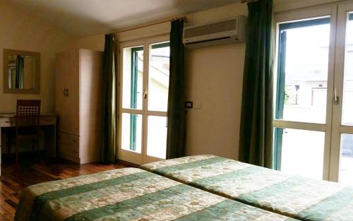 a bedroom with a bed and a large window at Hotel Borgo Verde in Catania