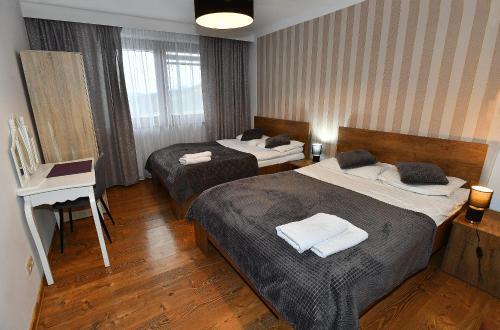 a hotel room with two beds and a desk at Dom na Słonnym in Manasterzec