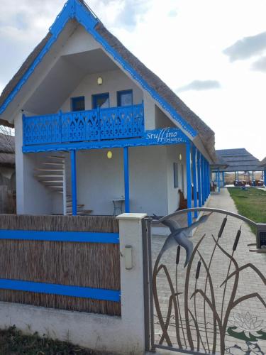 a blue and white house with a fence at Stuffino Crisan in Crisan