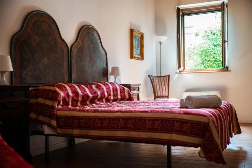 a bedroom with a large bed with a red blanket at Inferno e Paradiso in Gradara