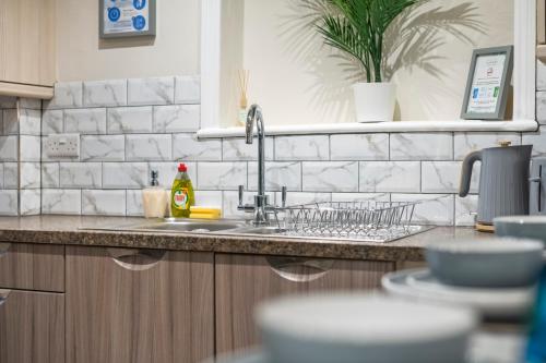 a kitchen counter top with a sink and a sink at Cooper House Stay - Large Stylish House in Oxford
