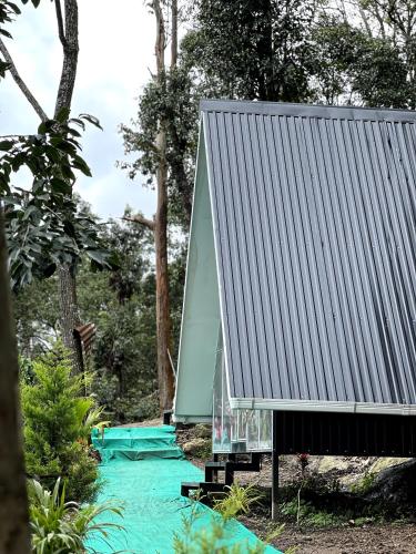 a house with a metal roof on a road at midwaytrip in Suryanelli
