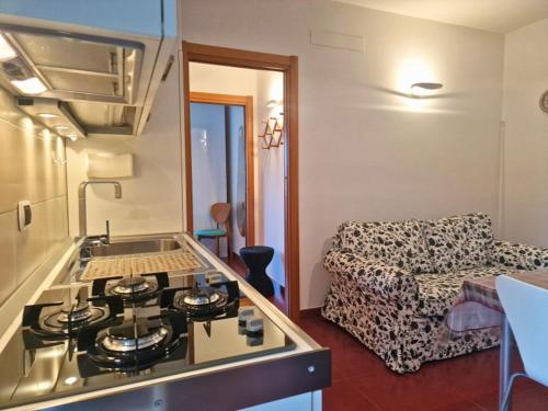 een keuken met een fornuis en een woonkamer met een bank bij Casa Vacanza Viale Italia in Vieste