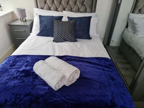 a bed with two rolls of towels on it at SAV Apartments Nottingham Road 1 & 2 Bed Flats Loughborough in Loughborough