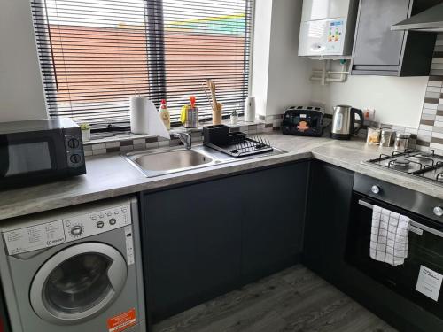 a kitchen with a washing machine and a sink at SAV Apartments Nottingham Road 1 & 2 Bed Flats Loughborough in Loughborough