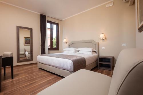 - une chambre d'hôtel avec un lit et un miroir dans l'établissement Window On Rome, à Rome