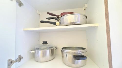 a kitchen with pots and pans on a shelf at Room For Rent in Antwerpen in Antwerp