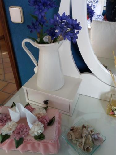 a table with a vase with flowers on it at Mas Valoria in Peratallada