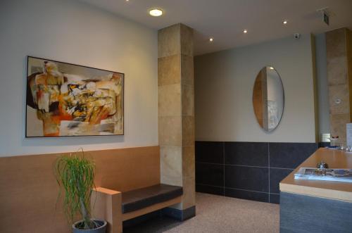 W łazience znajduje się umywalka i lustro. w obiekcie Hotel Pax w mieście Diksmuide