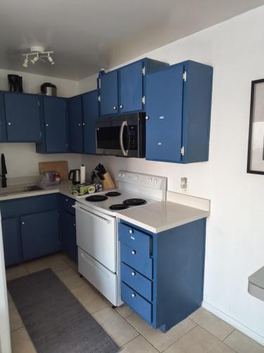 a kitchen with blue cabinets and a white stove top oven at 2 bdrm condo Las Vegas, NV in Las Vegas
