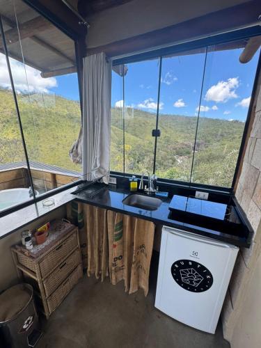 a kitchen with a sink and a window with a view at Rustik in Alto Paraíso de Goiás