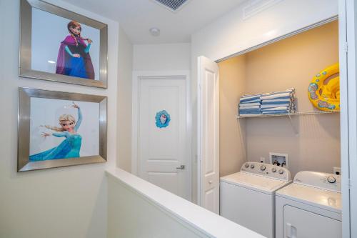 a white laundry room with a washer and dryer at Themed Disney House 5 min to Disney Parks, Heated Pool, Jacuzzi, Gym and more in Orlando