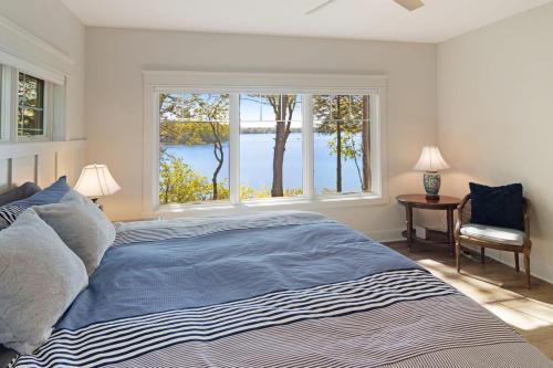 a bedroom with a large bed and a large window at Long Lake Fox Den - Dog Friendly in Traverse City