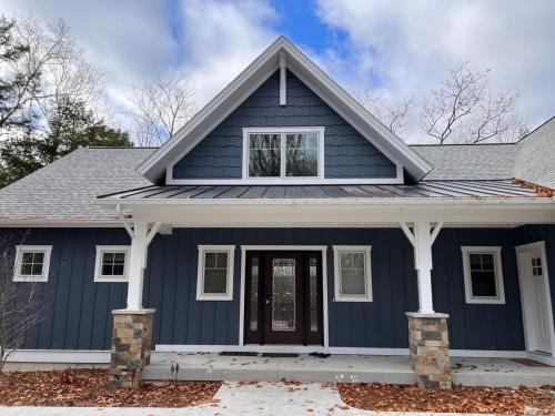 a blue house with a gray roof at Long Lake Fox Den - Dog Friendly in Traverse City