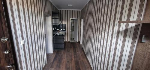 einen Flur mit Holzböden und gestreiften Wänden sowie eine Küche in der Unterkunft Стаи за гости Георги Сава Раковски 97 in Targowischte