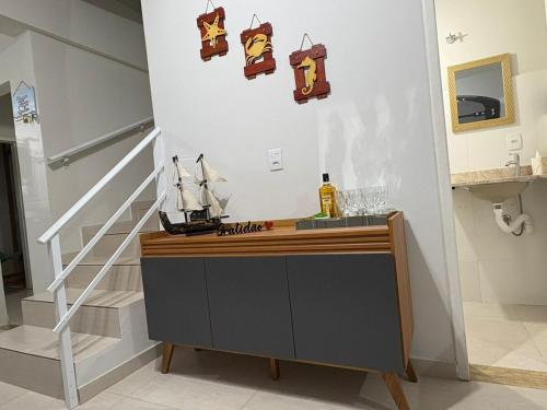 a room with a counter and a staircase with a sail boat on it at Geminado Itaguaçu - São Francisco do Sul in São Francisco do Sul