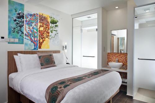 a bedroom with a large bed and a bathroom at Hotel Clover The Arts in Singapore