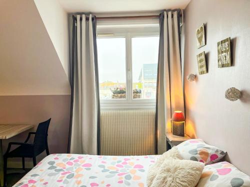a small bedroom with a bed and a window at Au Ptit Mousse - Hôtel et Restaurant in Courseulles-sur-Mer