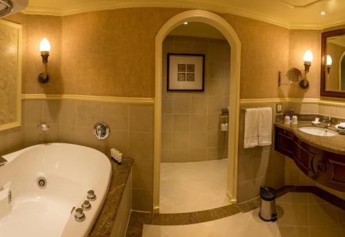 a bathroom with a tub and a sink at Peermont D'oreale Grande at Emperors Palace in Kempton Park