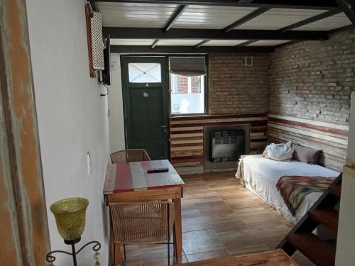 a bedroom with a bed and a desk and a fireplace at Azul en Lavalle 6 in Azul