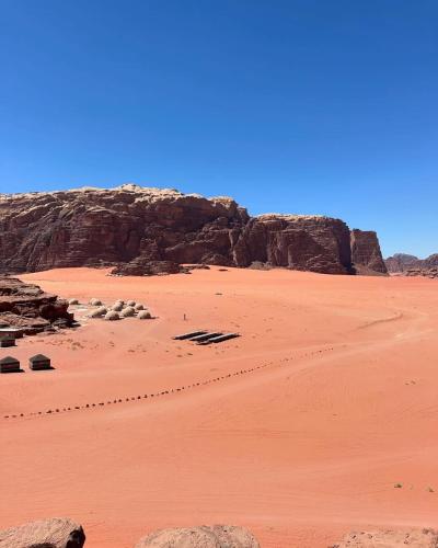 a view of a desert with rocks and sand at Wadi Rum Wild Camp Desert in Wadi Rum