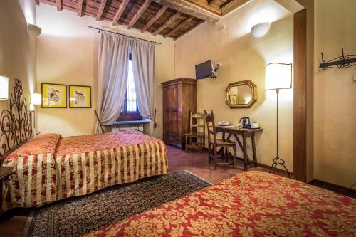 Un dormitorio con dos camas y una mesa y un escritorio. en Hotel Mario's, en Florencia