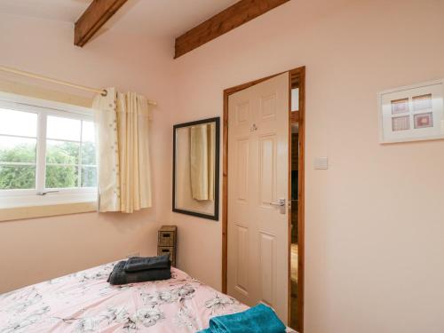 a bedroom with a bed and a window and a door at The Log Cabin in Swindon