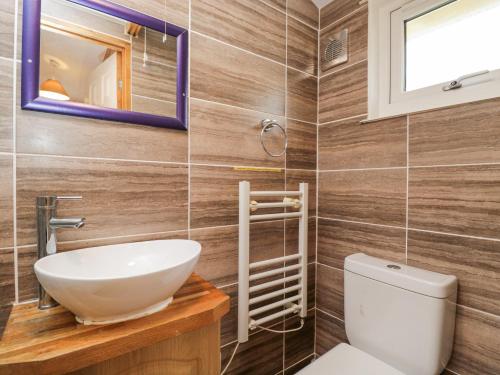 a bathroom with a sink and a toilet at The Log Cabin in Swindon