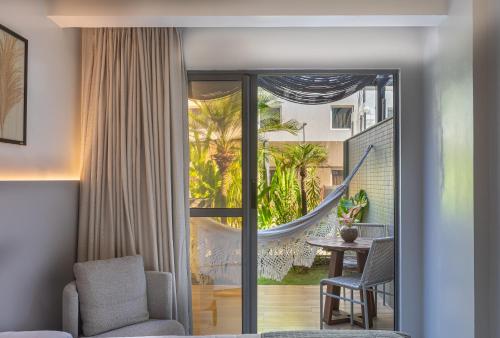 a room with a sliding glass door with a hammock at Icon Hotel by Welkom in João Pessoa