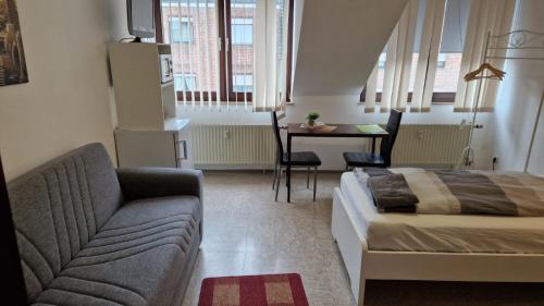 a bedroom with a bed and a couch and a table at Zimmer D in Mönchengladbach