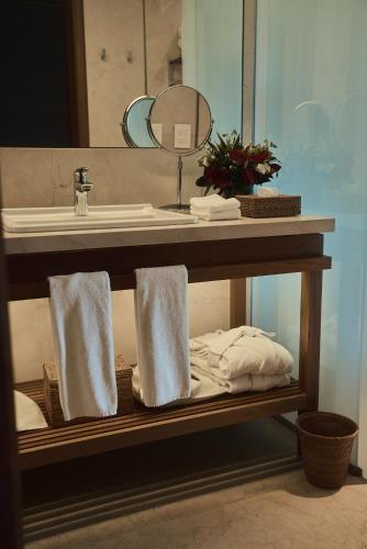 a bathroom with a sink and a shelf with towels at Hotel Fasano Angra dos Reis in Angra dos Reis