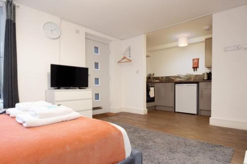 a large room with a bed and a kitchen at SAV Stays Apartments Regent Leicester in Leicester