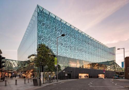 a large glass building with a blue facade at SAV Apartments Regent Leicester in Leicester