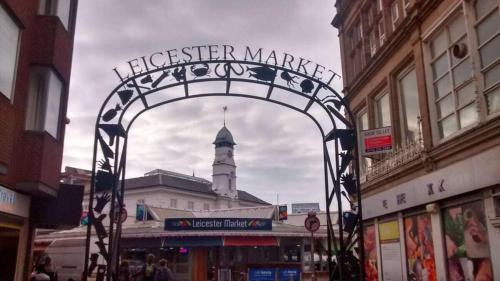 a gate in a city with a clock tower at SAV Apartments Regent Leicester in Leicester