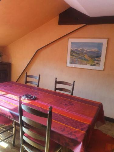 une salle à manger avec une table et des chaises rouges dans l'établissement Lourdes grand appartement de caractère, à Lourdes