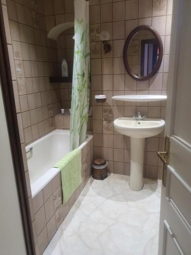 une salle de bain avec une baignoire et un lavabo et une baignoire dans l'établissement Lourdes grand appartement de caractère, à Lourdes