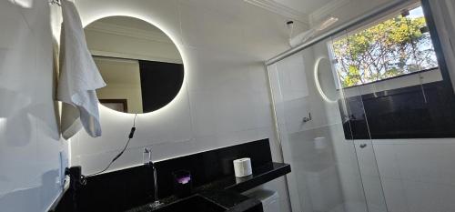 a bathroom with a sink and a mirror at Apartamento Novo in Porto Seguro