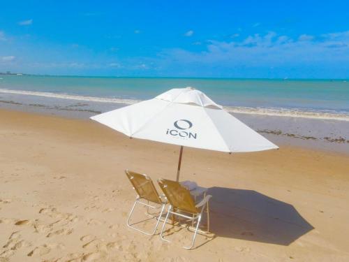 two chairs and an umbrella on the beach at Icon Hotel by Welkom in João Pessoa