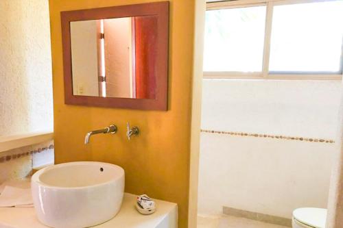 a bathroom with a sink and a mirror at Kastelorizo Private Beachfront house in Chicxulub